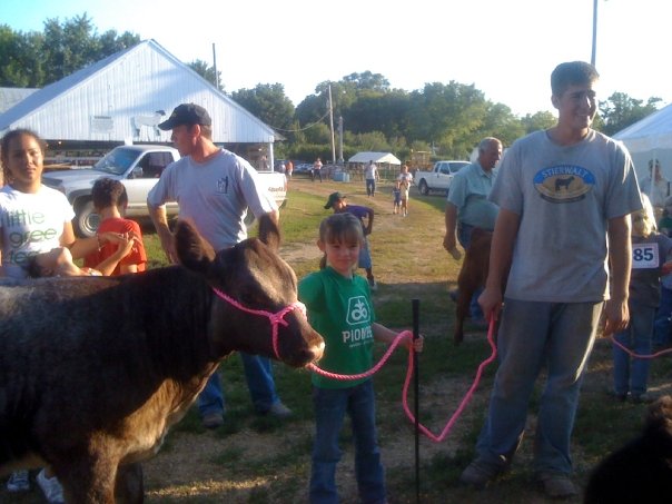 a group of people and a small bull